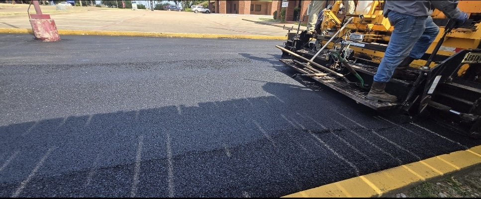 Asphalt paving machine working on a commercial paving surface